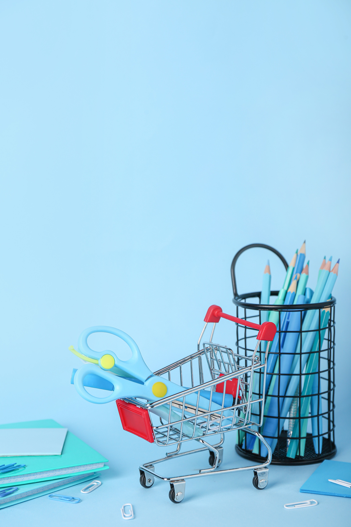 Shopping Cart with Stationery on Blue Background